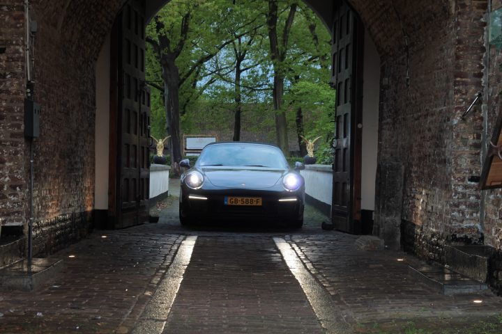 Een auto rijdt door de historische toegangspoort van het kasteel