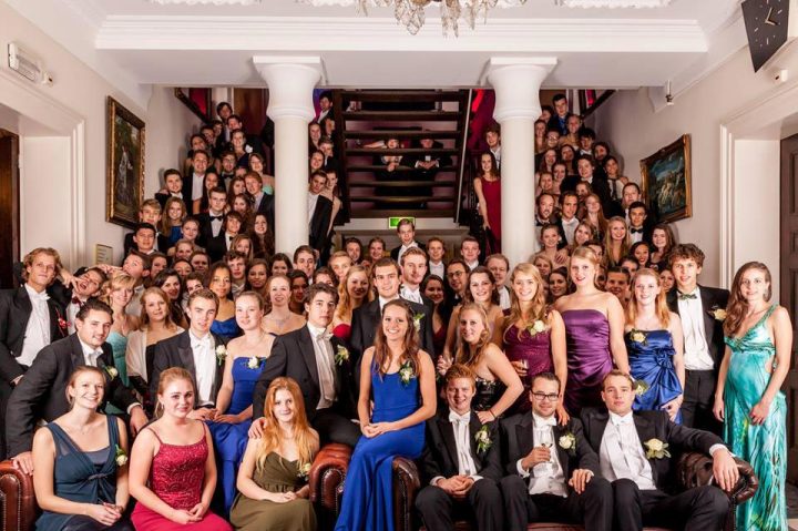 Groepsfoto van studenten in galakleding op de kasteeltrap